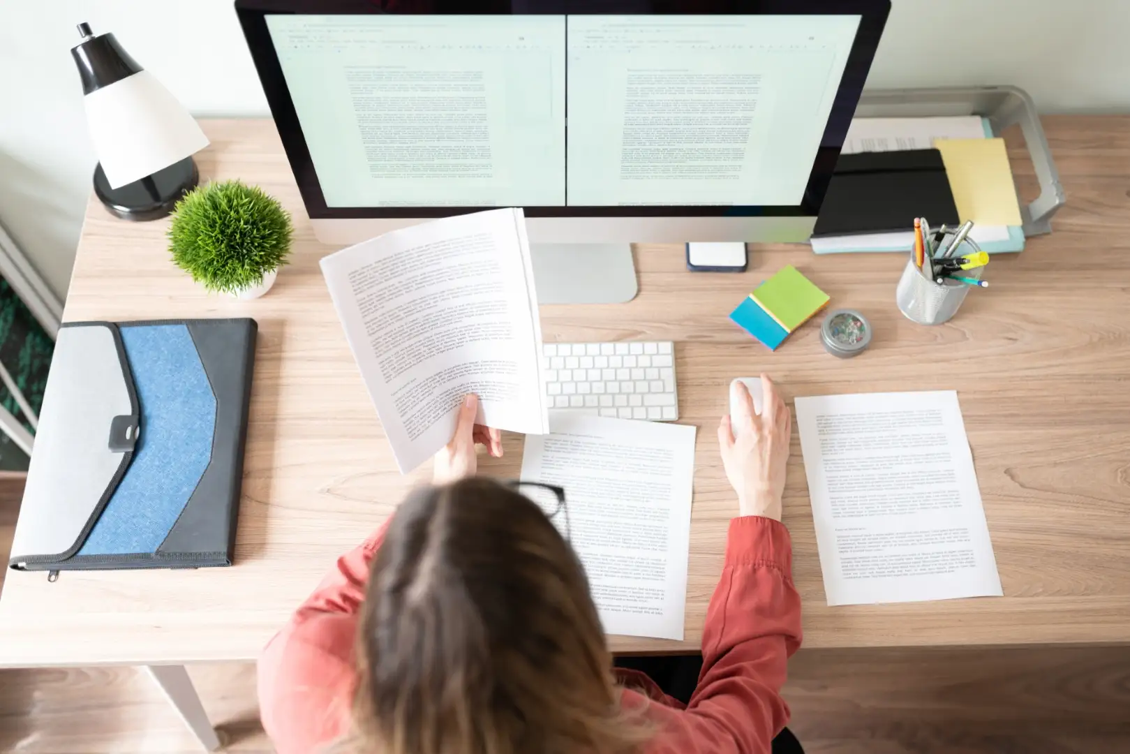 Mastering Blog Writing: Tips and Techniques for Engaging Content Woman working on blog writing at a desk with dual monitors.